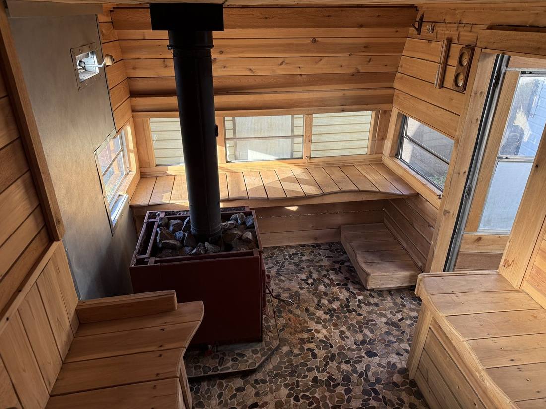 Inside The Cousin Eddie — cedar benches, wood stove and river rock floor